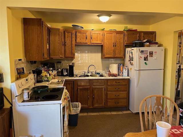 kitchen featuring sink, white appliances, light tile patterned floors, and backsplash