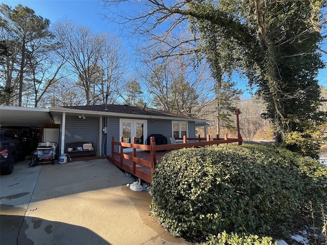 exterior space with a carport, french doors, and a deck