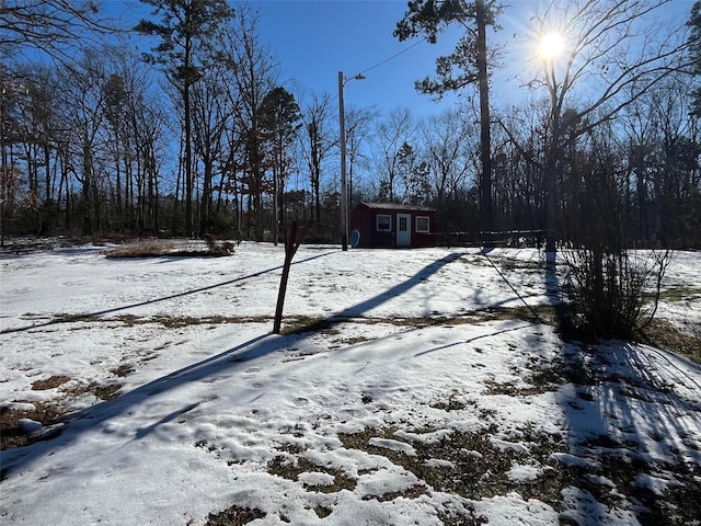 yard covered in snow with a storage unit