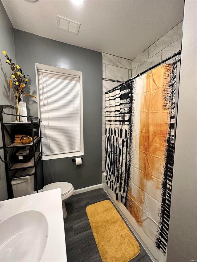 full bathroom with wood-type flooring, sink, shower / bathtub combination with curtain, and toilet