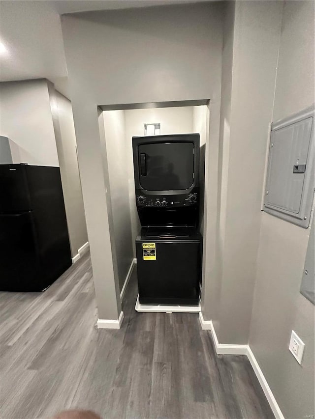 kitchen featuring wood-type flooring, electric panel, and black fridge