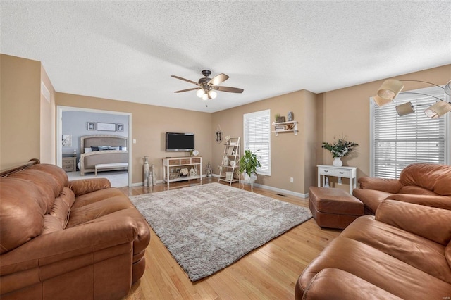 living room with hardwood / wood-style floors, a textured ceiling, plenty of natural light, and ceiling fan