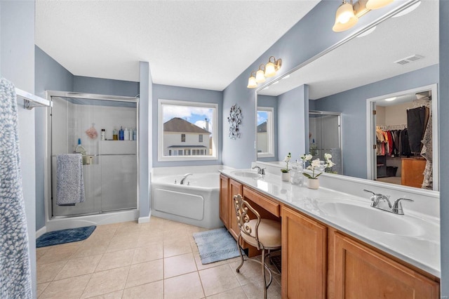 bathroom with plus walk in shower, tile patterned floors, a textured ceiling, and vanity