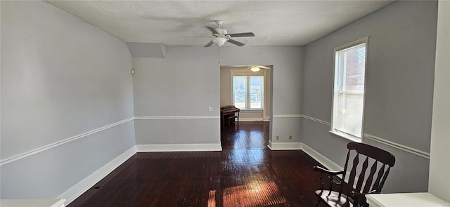 empty room with plenty of natural light, dark hardwood / wood-style floors, and ceiling fan