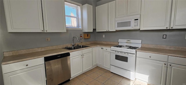 kitchen featuring white appliances, light tile patterned floors, sink, and white cabinets