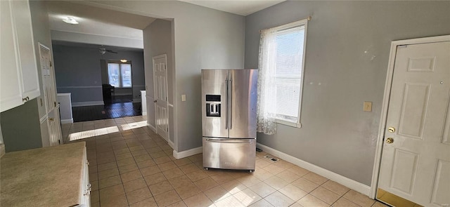 kitchen featuring light tile patterned flooring, high quality fridge, ceiling fan, and white cabinets