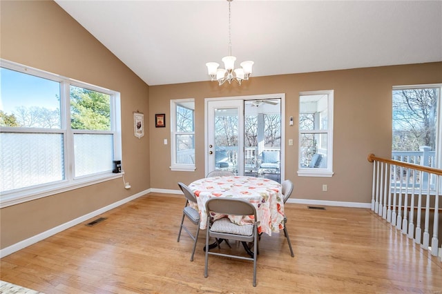 dining room featuring lofted ceiling, a chandelier, and light hardwood / wood-style floors