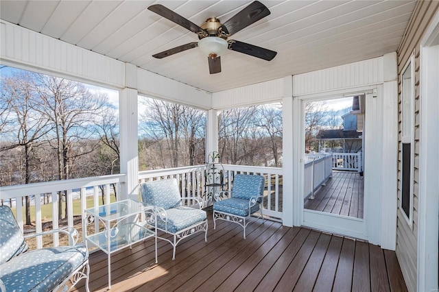 unfurnished sunroom with ceiling fan