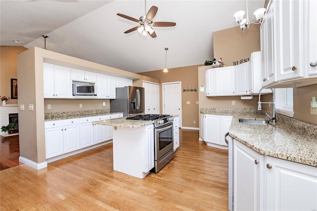 kitchen featuring a kitchen island, appliances with stainless steel finishes, pendant lighting, sink, and white cabinets