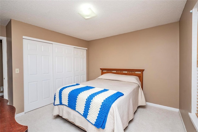 carpeted bedroom featuring a closet and a textured ceiling