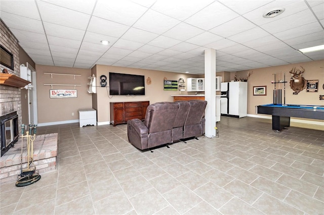 tiled living room featuring a brick fireplace, a paneled ceiling, and billiards