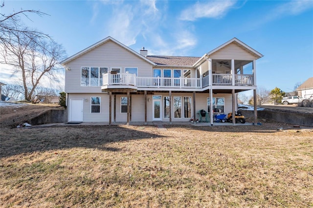 rear view of house featuring a deck, ceiling fan, and a lawn