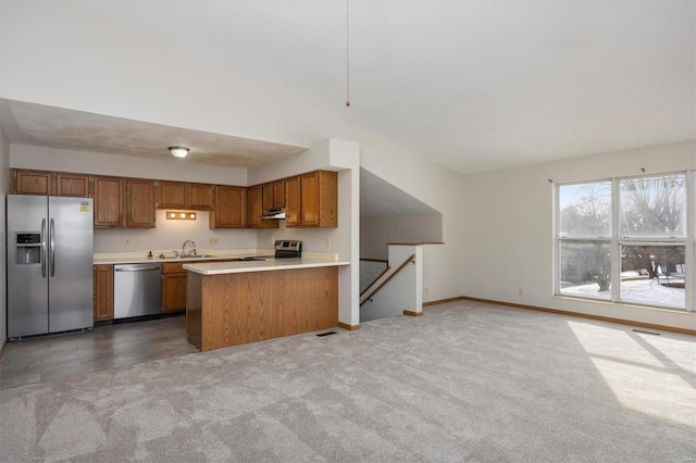 kitchen with light carpet, sink, stainless steel appliances, and kitchen peninsula