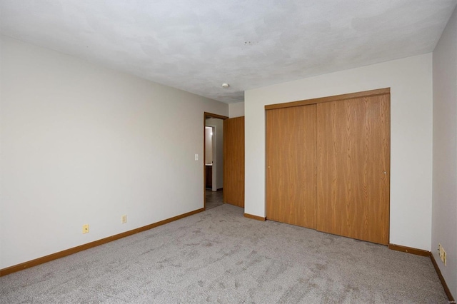 unfurnished bedroom featuring light carpet and a closet