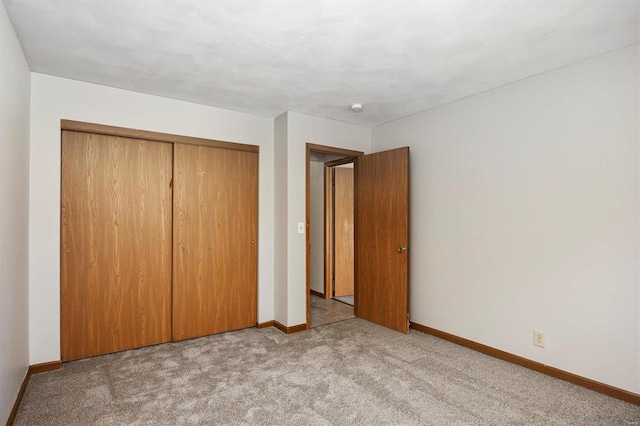 unfurnished bedroom featuring light colored carpet and a closet