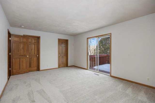 unfurnished bedroom with light colored carpet and access to exterior