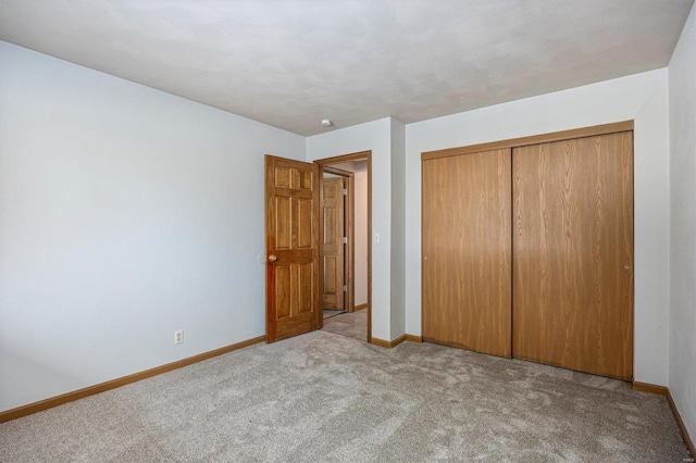 unfurnished bedroom with light carpet and a closet