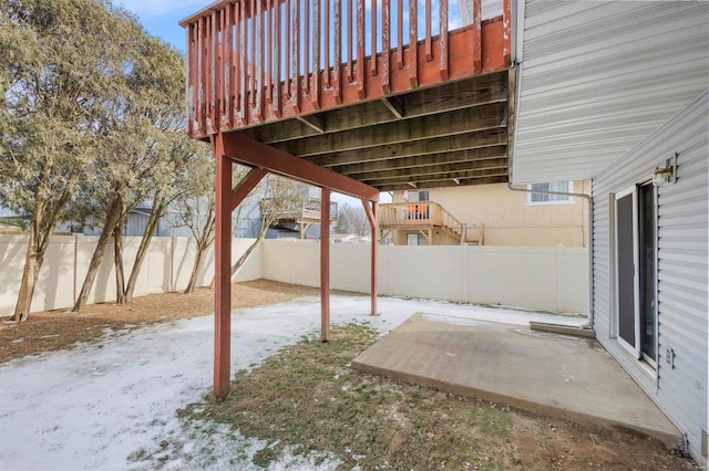 snow covered patio featuring a wooden deck