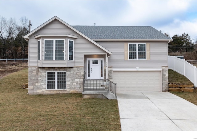 bi-level home featuring a garage and a front yard