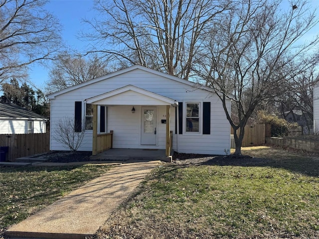 view of front of property featuring a porch, a front yard, and fence