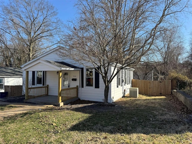 bungalow-style house featuring a porch, cooling unit, a front yard, and fence