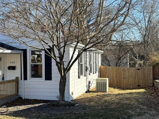 view of side of property featuring cooling unit and fence