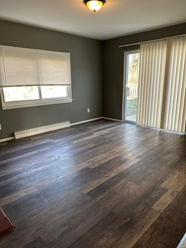 spare room with dark hardwood / wood-style flooring and baseboard heating