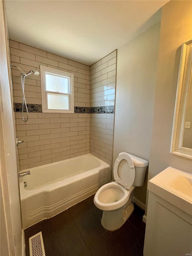 full bathroom featuring vanity, toilet, and tiled shower / bath combo