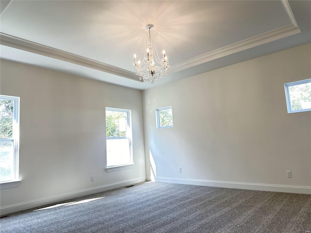 unfurnished room with crown molding, a raised ceiling, a chandelier, and carpet flooring