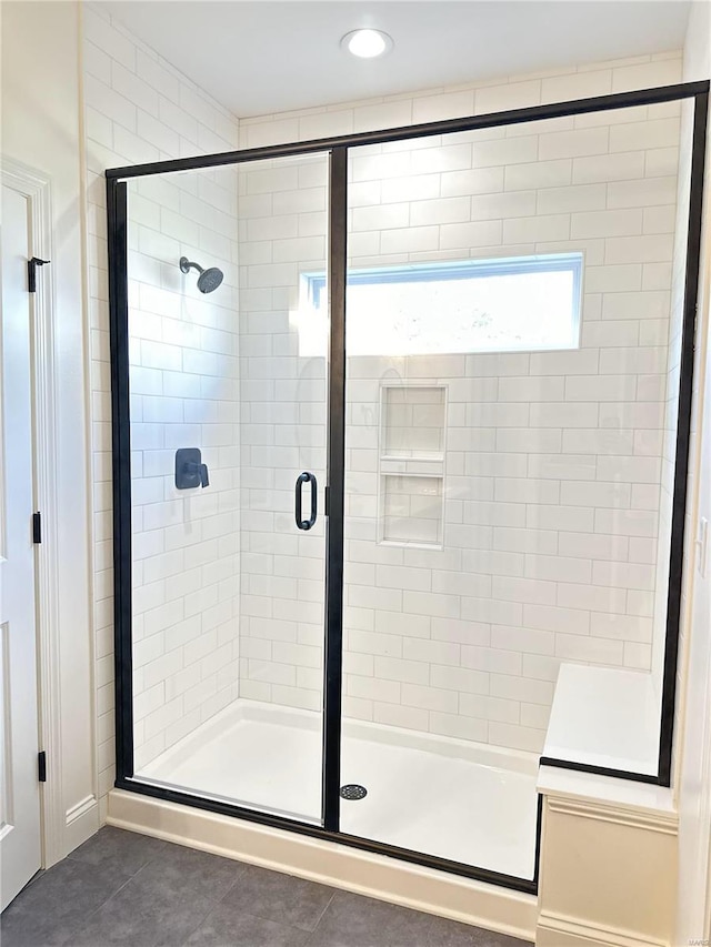 bathroom with tile patterned floors and a shower with shower door