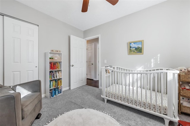 bedroom featuring a nursery area, ceiling fan, and carpet