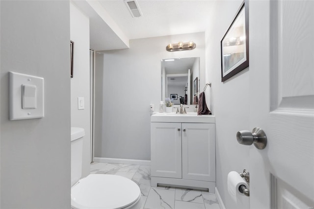 bathroom with vanity, toilet, and a textured ceiling