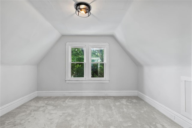 bonus room with light colored carpet and lofted ceiling