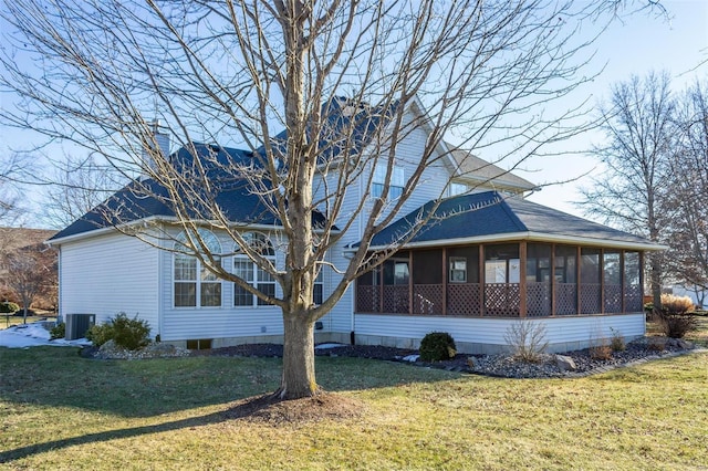 view of side of home featuring a sunroom, central AC unit, and a lawn