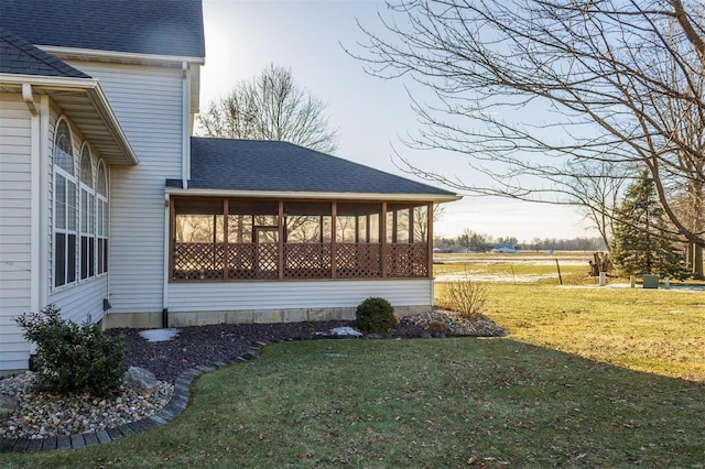 view of side of property featuring a sunroom and a yard