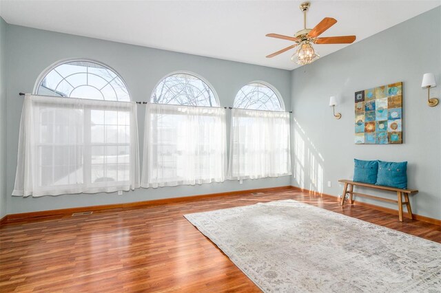 sitting room featuring wood-type flooring and ceiling fan