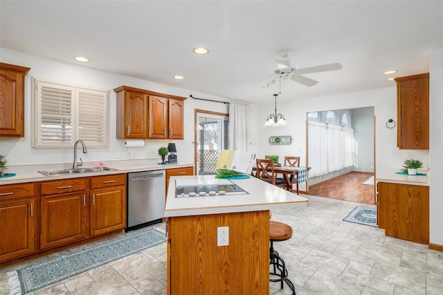 kitchen with sink, a breakfast bar area, dishwasher, a kitchen island, and decorative light fixtures