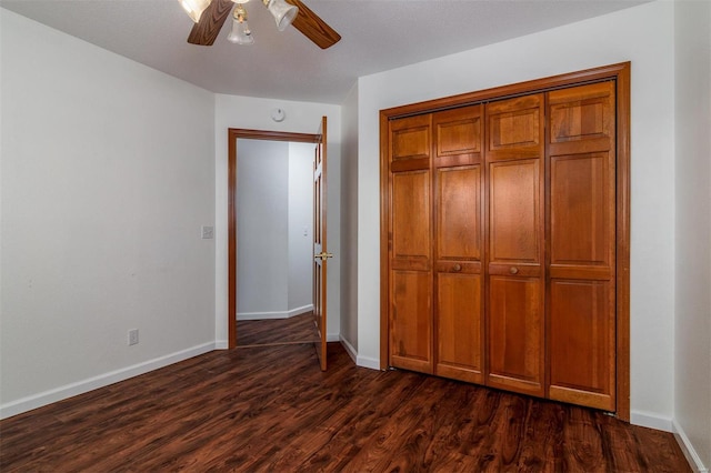 unfurnished bedroom with dark hardwood / wood-style floors, ceiling fan, and a closet