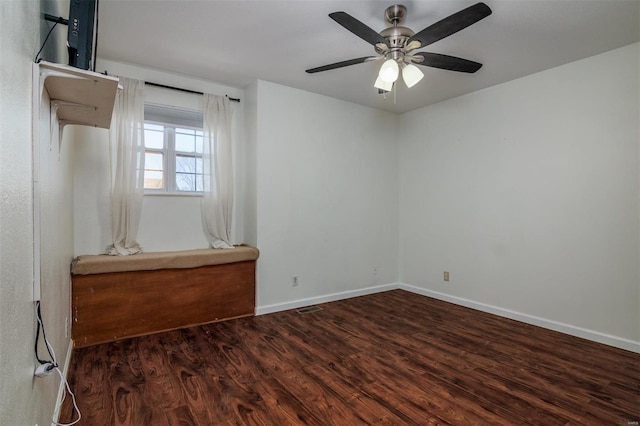 empty room featuring dark wood-type flooring and ceiling fan