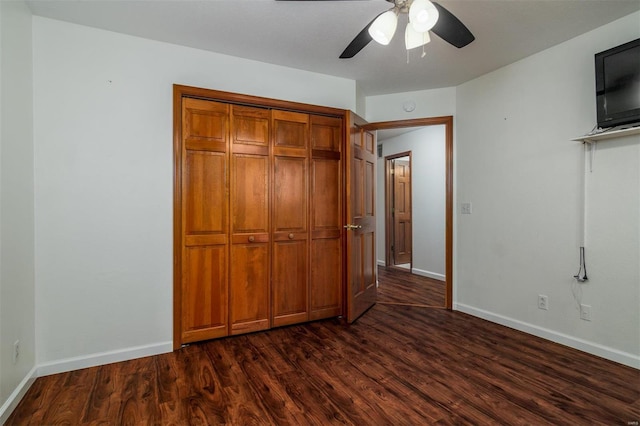 unfurnished bedroom featuring dark hardwood / wood-style floors, ceiling fan, and a closet