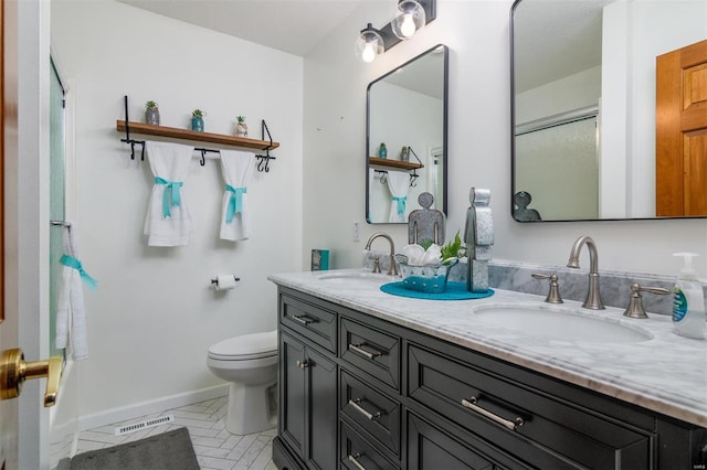 bathroom featuring vanity, toilet, and a shower with shower door