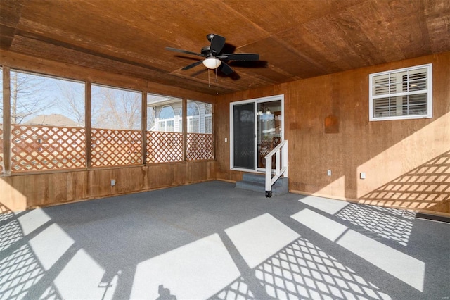 unfurnished sunroom featuring wooden ceiling and ceiling fan