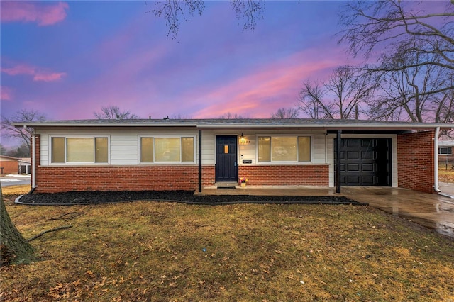 ranch-style home featuring a garage, a lawn, and a carport