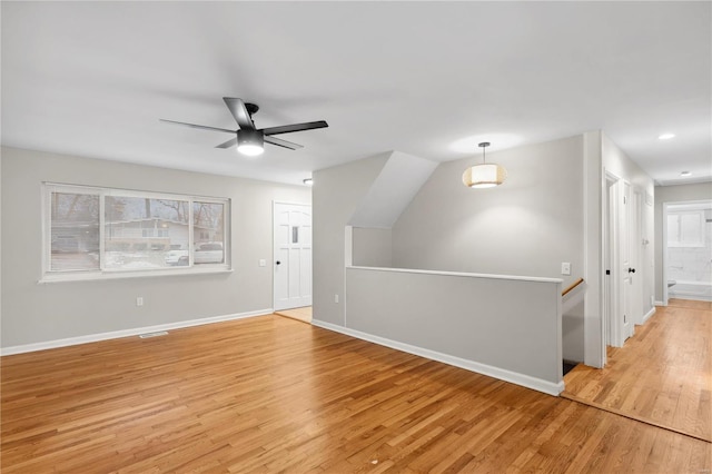 additional living space with ceiling fan and light hardwood / wood-style flooring