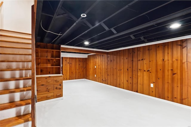 basement featuring wooden walls