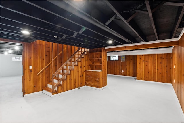 basement featuring wooden walls