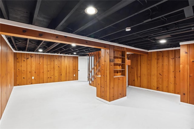 basement featuring wood walls