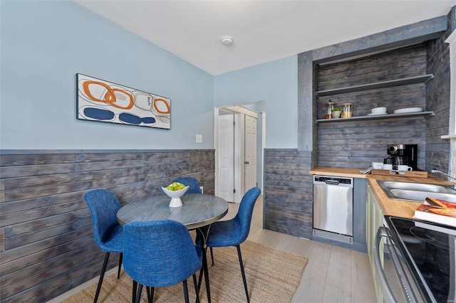 kitchen with stainless steel appliances, sink, wooden counters, and light wood-type flooring