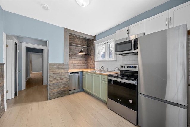 kitchen with sink, green cabinetry, wooden counters, stainless steel appliances, and white cabinets