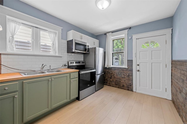 kitchen featuring butcher block counters, sink, white cabinetry, green cabinetry, and stainless steel appliances